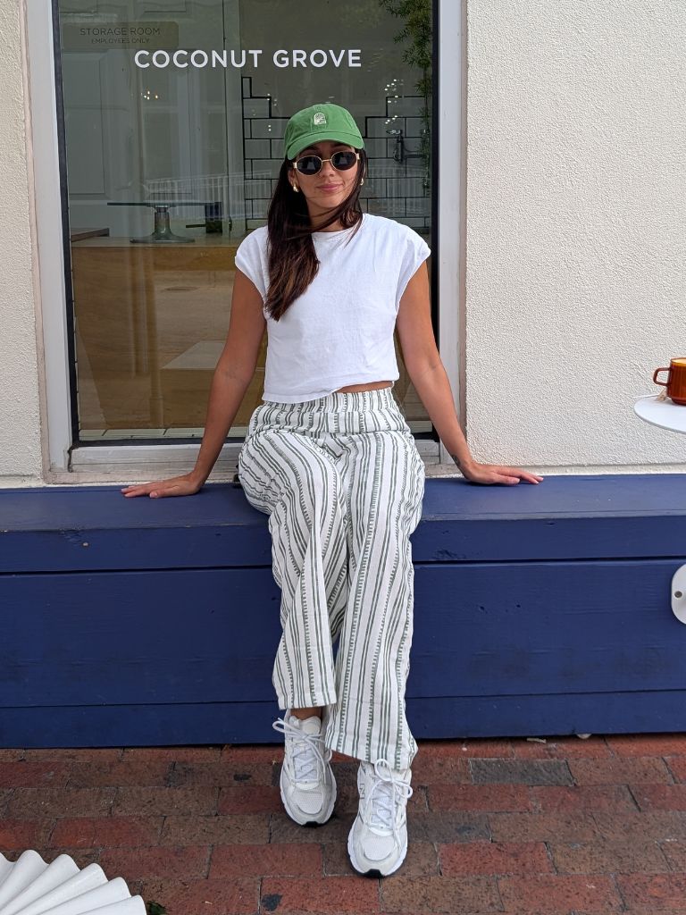 Model wearing relaxed-fit white linen pants with green stripes – resort wear look by Parce Miami