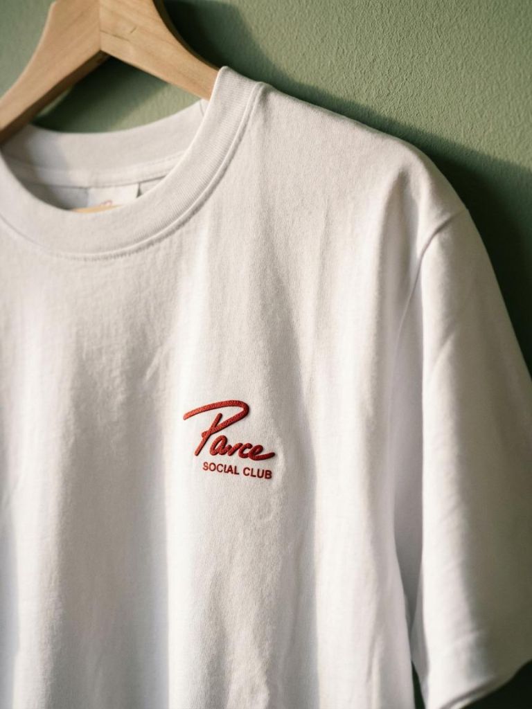 Close-up of cotton Parce Social Club logo on premium white Peruvian cotton tee