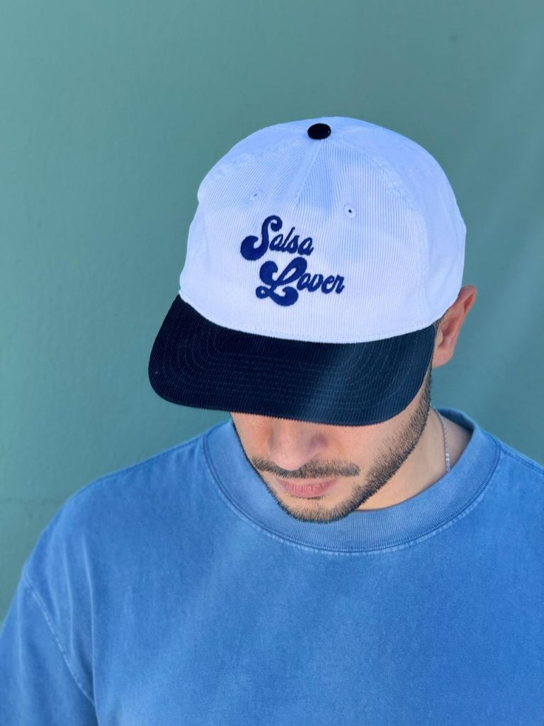 Person wearing a white and black cap with 'Salsa Lover' text against a teal background