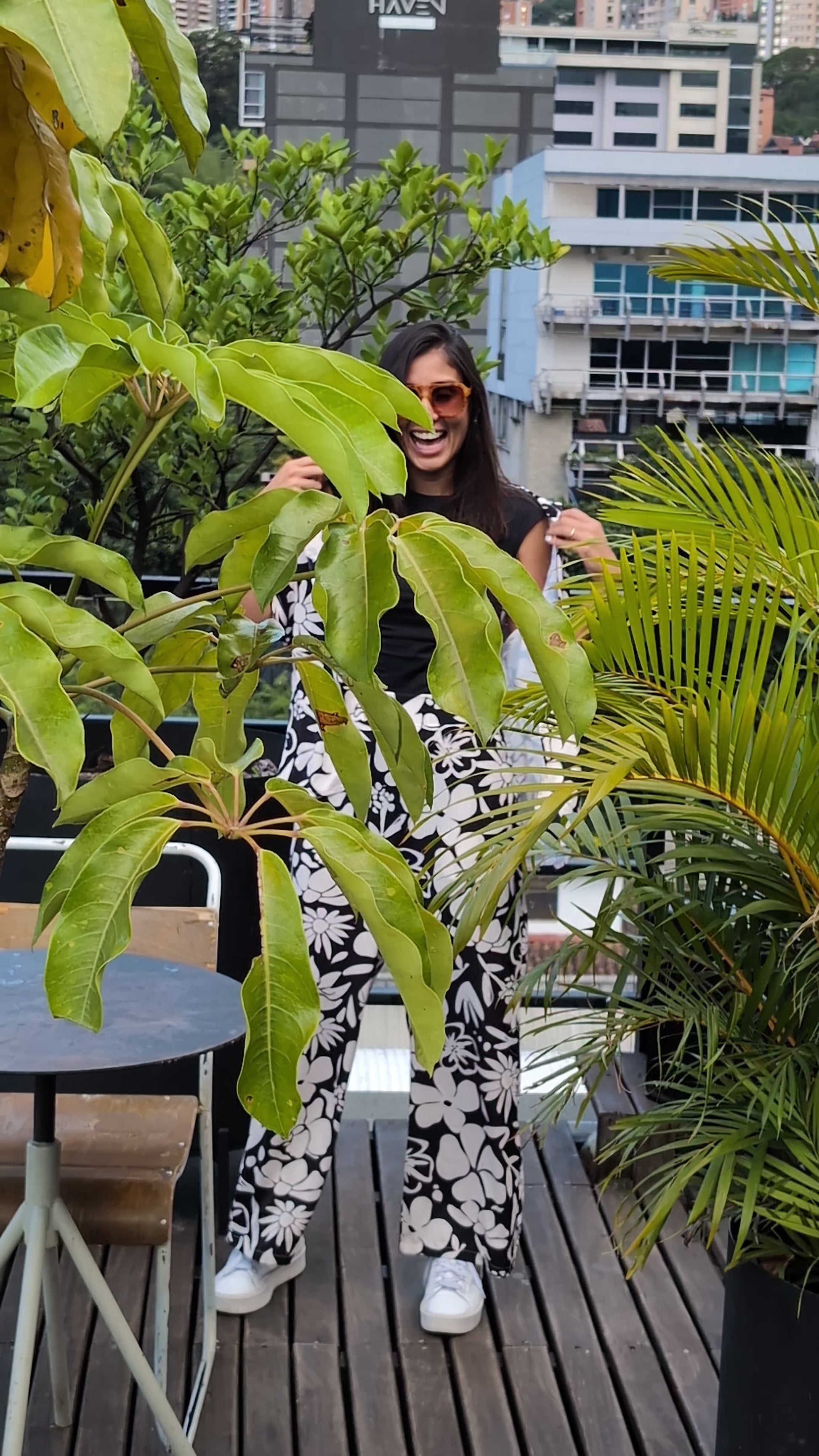 A tall woman wearing the black and white floral set on top of a beautiful rooftop in Medellin