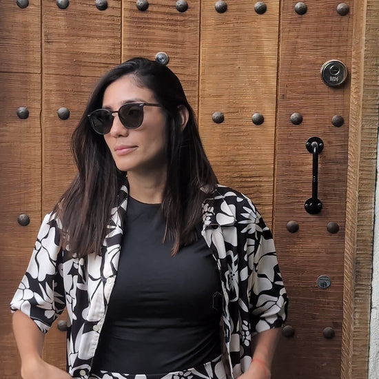 A tall woman wearing the black and white floral set on top of a beautiful rooftop in Medellin