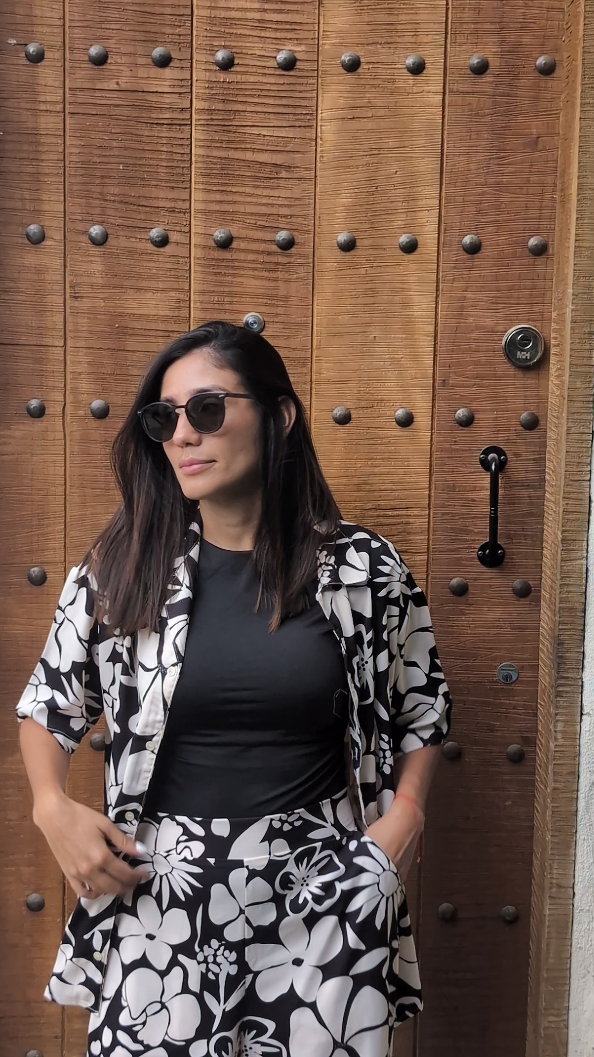 A tall woman wearing the black and white floral set on top of a beautiful rooftop in Medellin